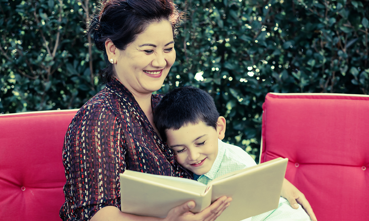 Woman smiling while reading to a child
