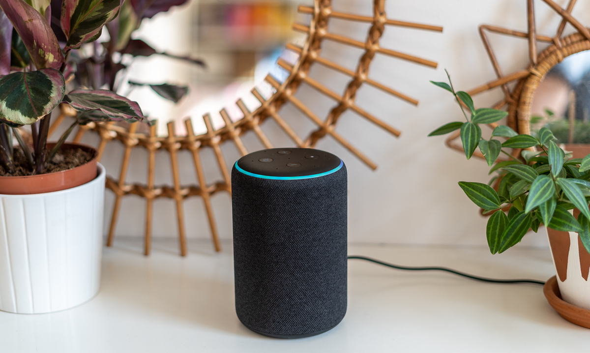An Alex home help device sitting on a shelf in front of a mirror