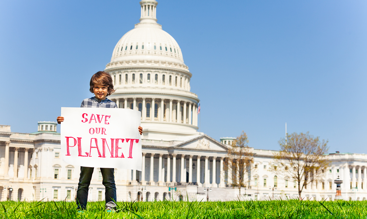 Kid holding protest sign in front of the white house