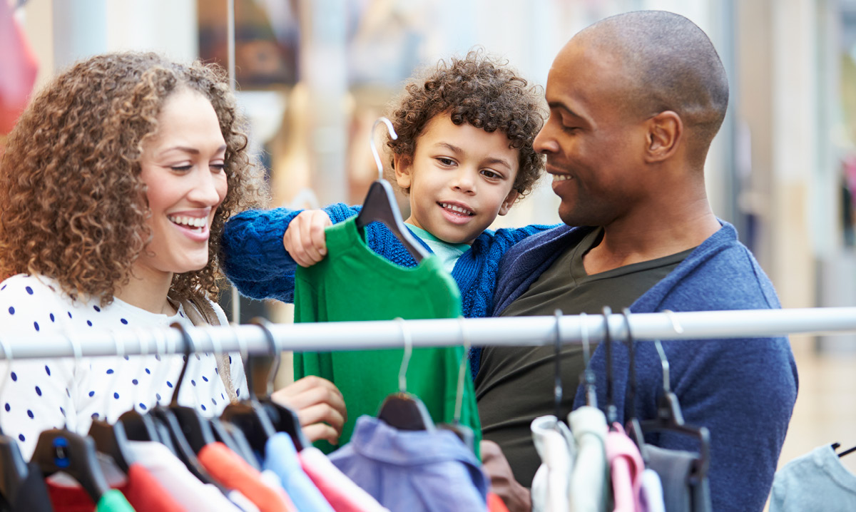 Family of three shopping a mom-to-mom sale