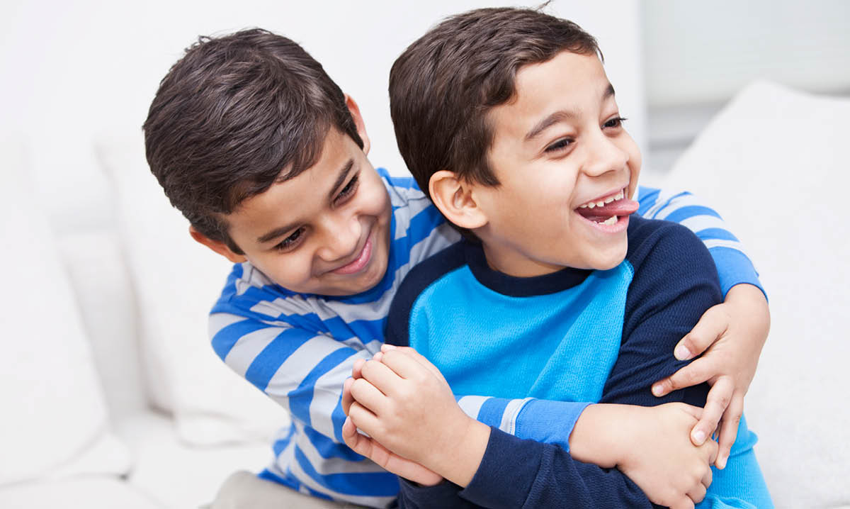 Two young boys hugging each other