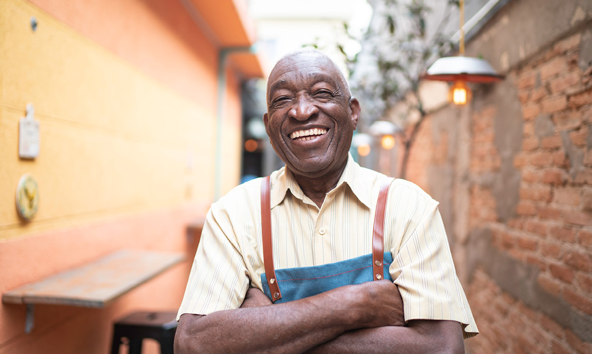 Elderly cashier with arms folded and smiling