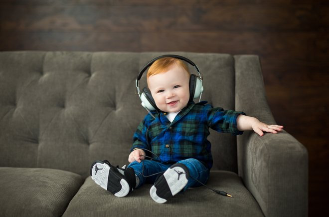 Baby sitting on a couch wearing headphones