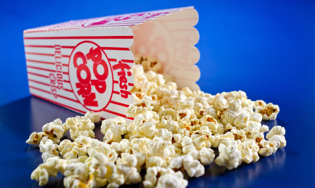 Spilled movie theater popcorn on a blue background