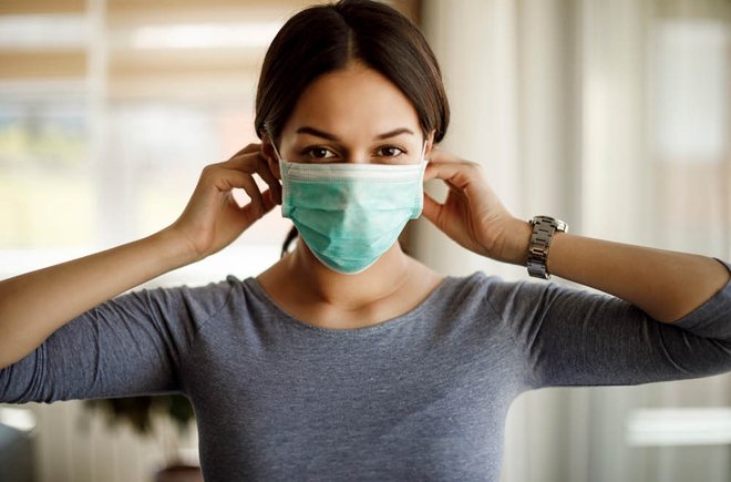 Woman putting on a face mask