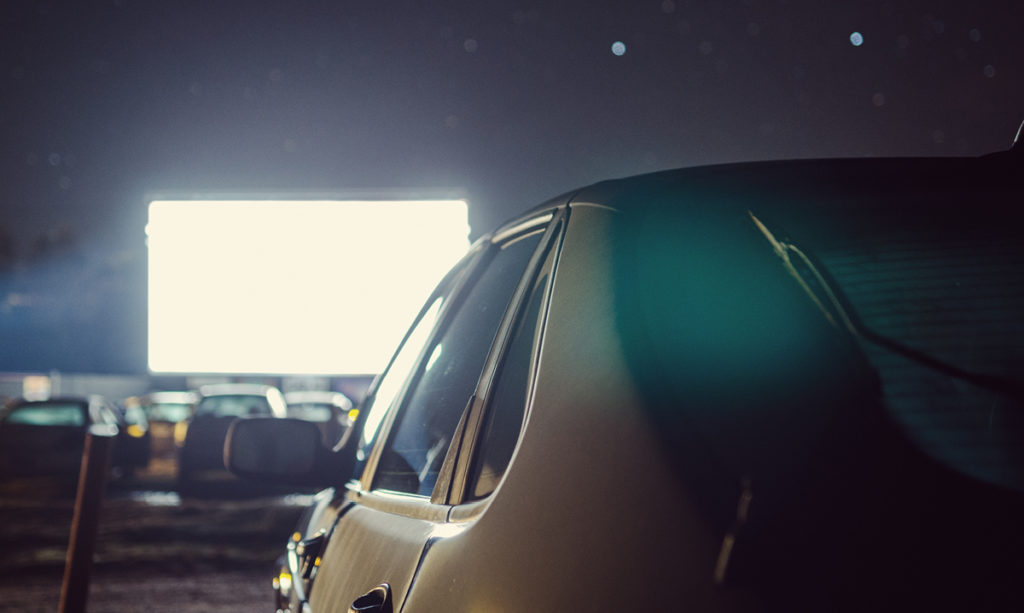 A car parked at a drive-in movie