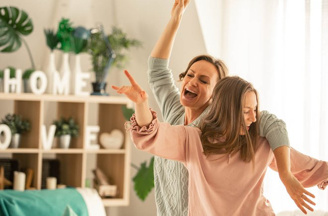 A mom and daughter dancing together