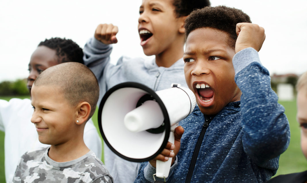 Kids protesting. One yelling into a megaphone