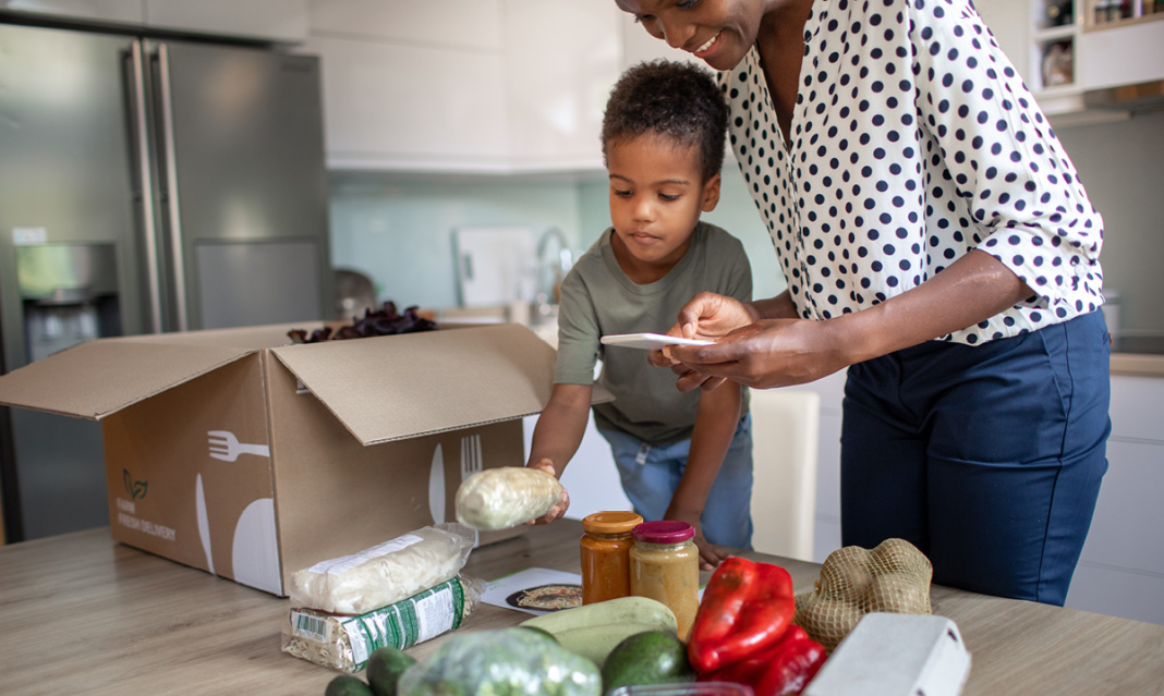 Mon and child unpacking a cooking box