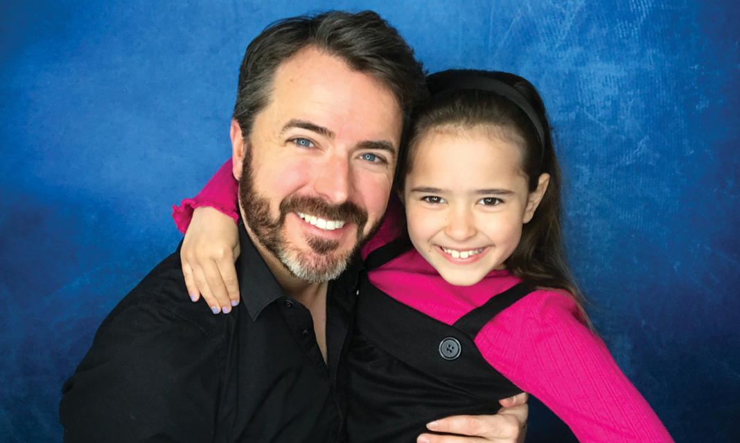 A man and girl smiling on a blue background