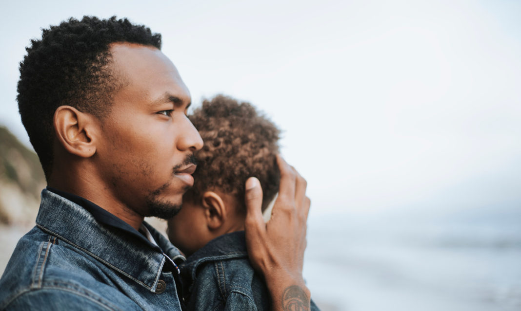 A black man holding a small child
