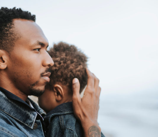 A black man holding a small child