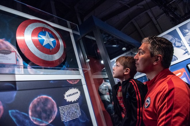 Man and child looking at Captain America shield