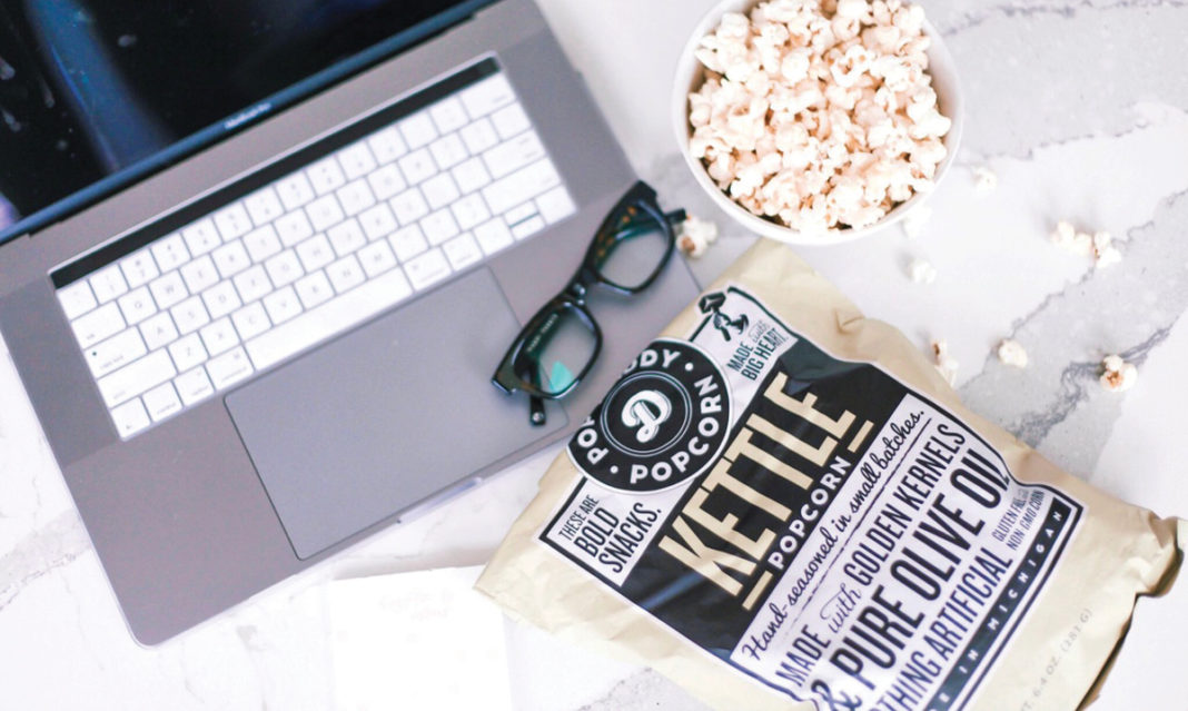 A bag of Pop Daddy Popcorn spilled on a computer
