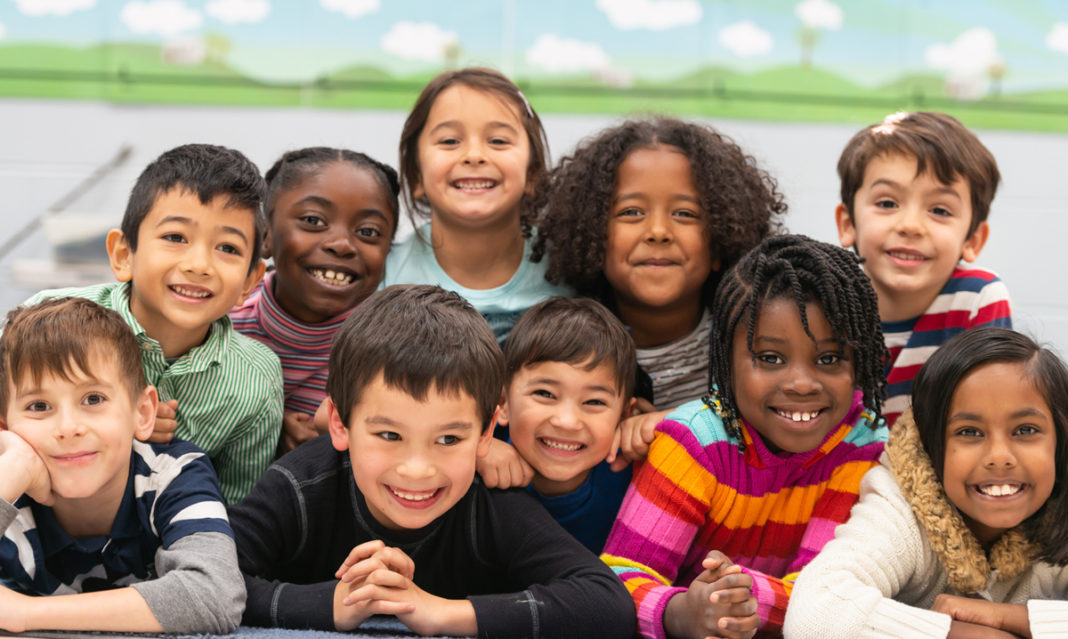 A group of kids of different races smiling together
