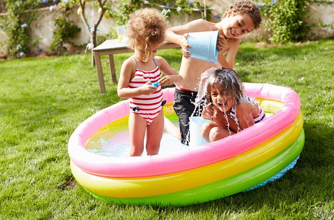 Three kids playing in a kiddie pool