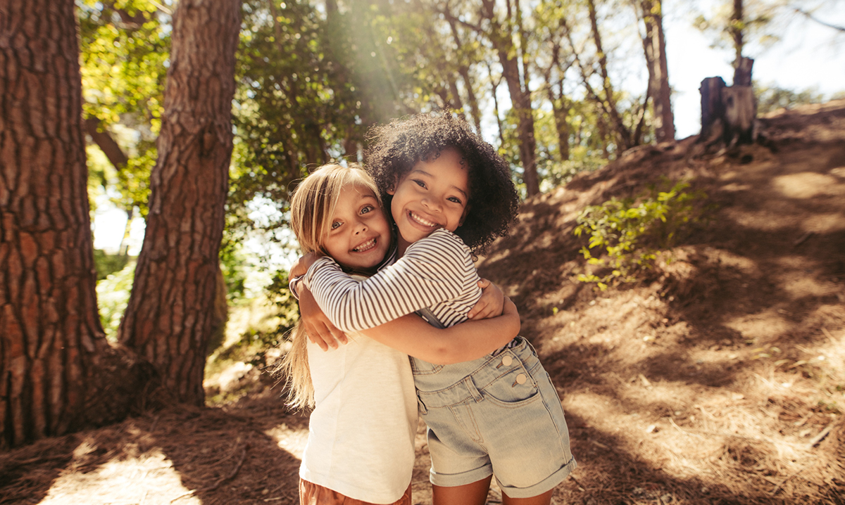 Two little girls hugging and smiling