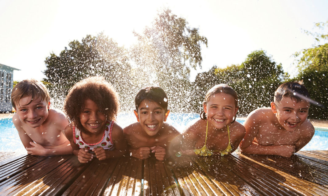 Group of kids of different races playing in a pool together