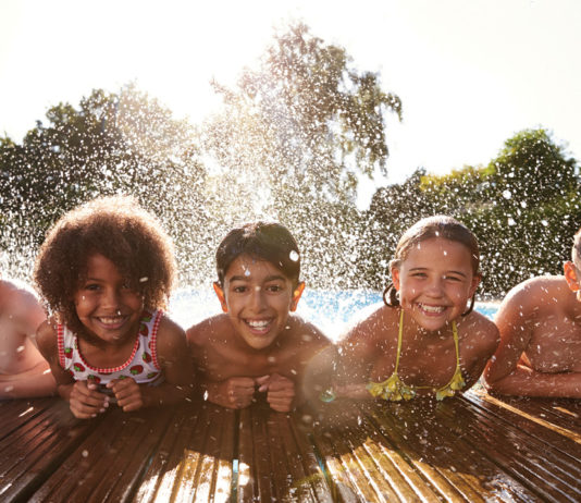Group of kids of different races playing in a pool together