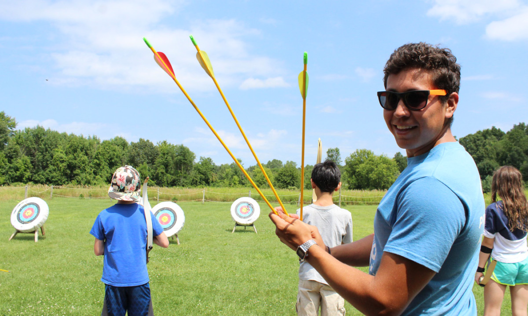 Kid holding arrows at camp