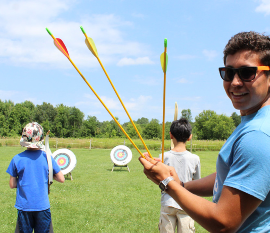 Kid holding arrows at camp