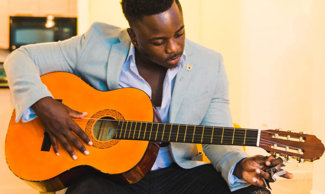 a Black man playing a guitar