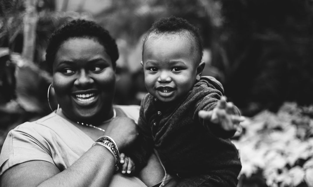A black and white image of a mom holding her baby