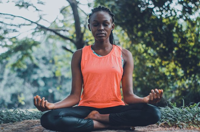 a Black woman in lotus pose