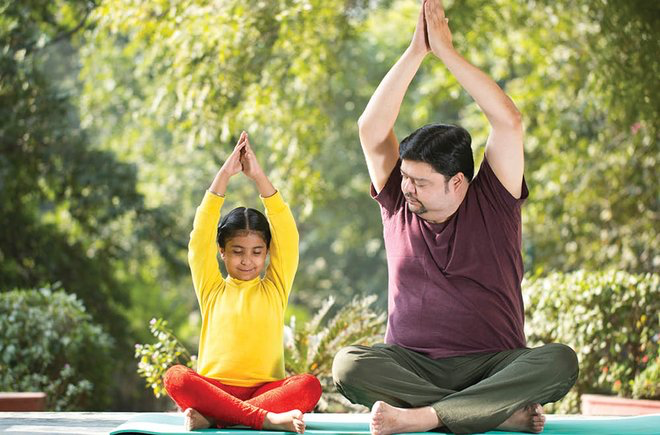 A man and child doing a yoga pose