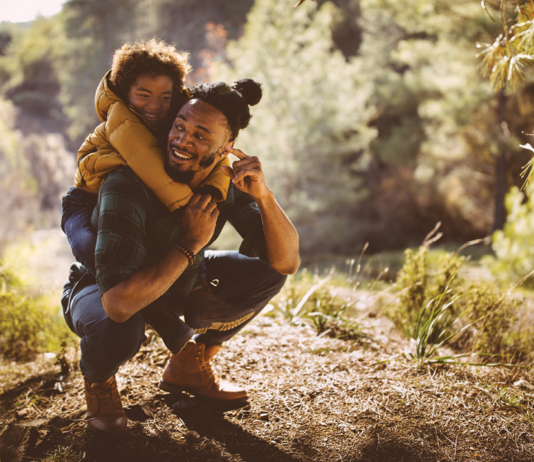 Thanksgiving for Nature at the Farmington Hills Nature Center A man giving a child a piggy-back ride up a mountain