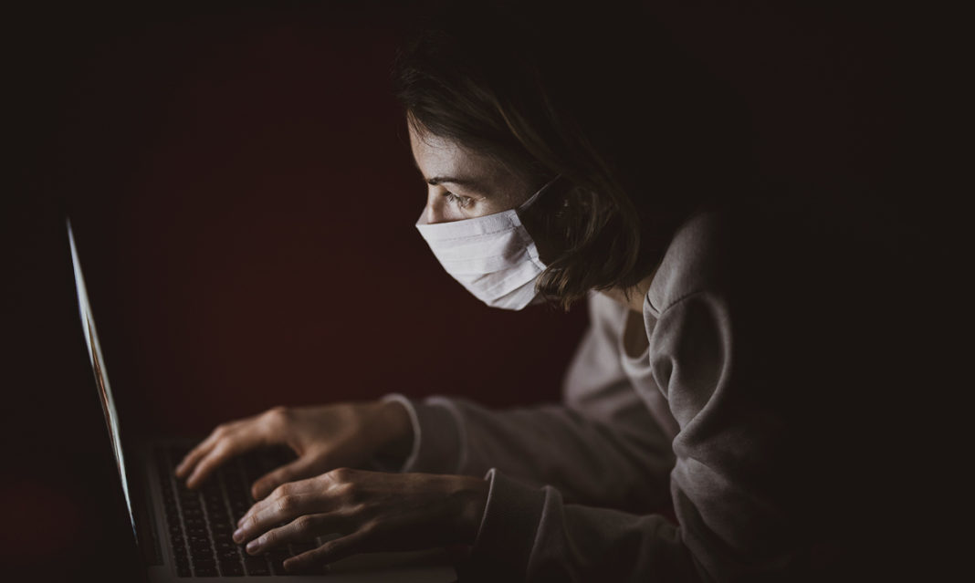 Girl in a mask on her computer