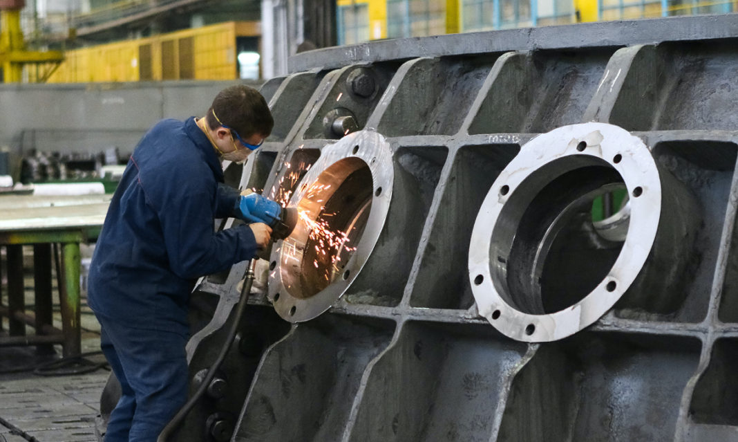 A man welding a large piece of machinery