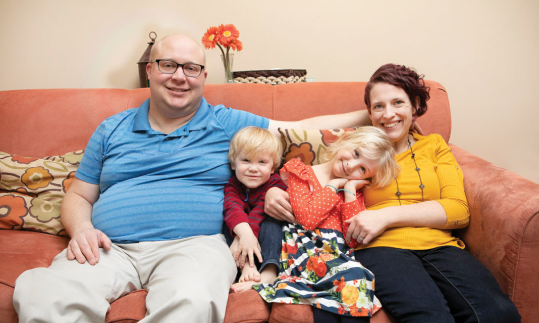Christine Dubois and family sitting on her couch
