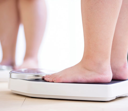 Close-up of feet standing on a scale
