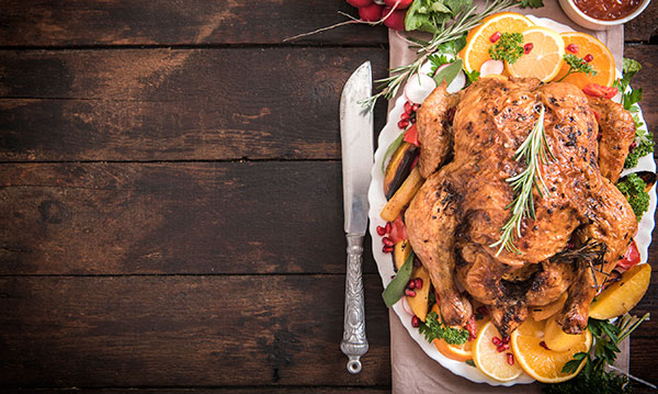 A cooked turkey on a plate on a wood background