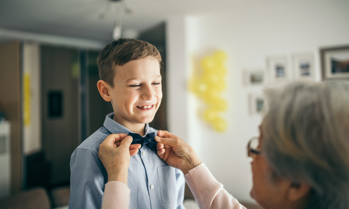 Person straightening a young boy's bowtie