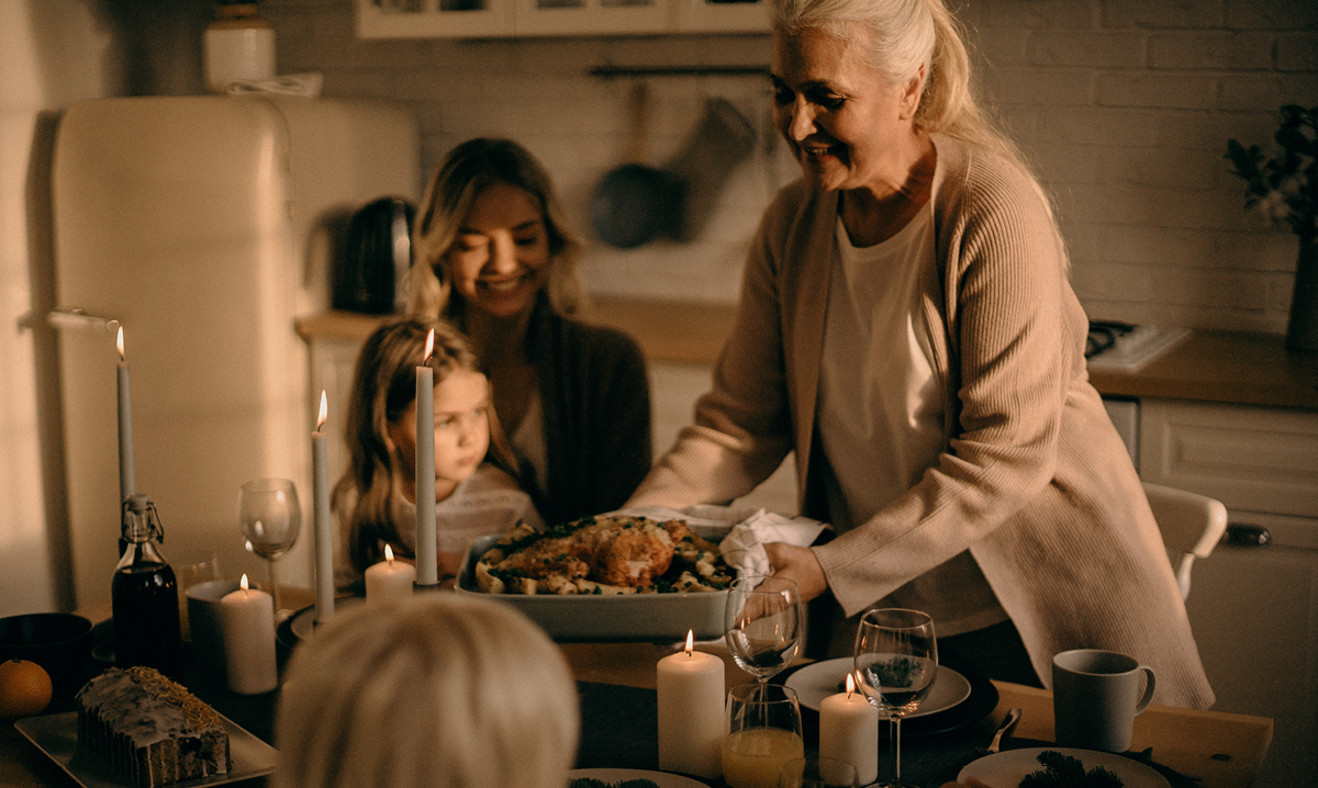Older woman serving turkey to a young woman and a child