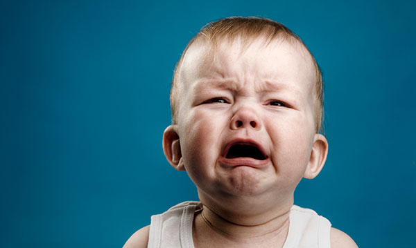 Baby crying on a blue background