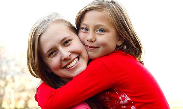 Little girl hugging woman