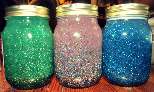 Three jars filled with colorful water and glitter