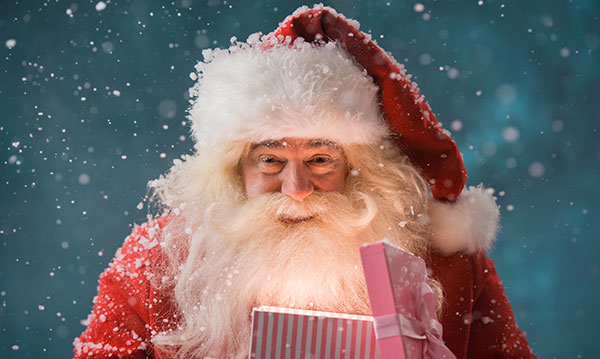 Santa holding a glowing present on a blue background