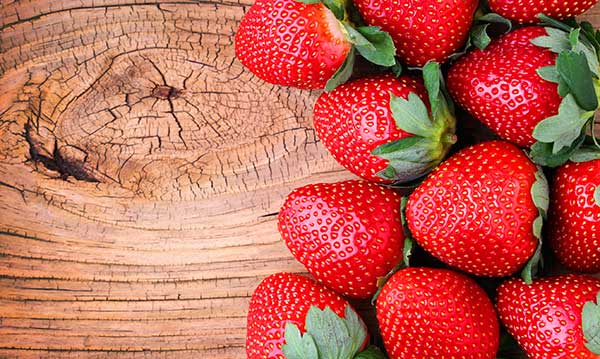 Pile of strawberries on a piece of wood