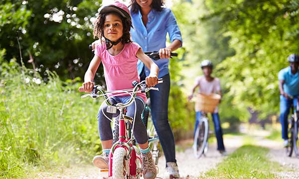 Mom and daughter riding their bikes along a trail