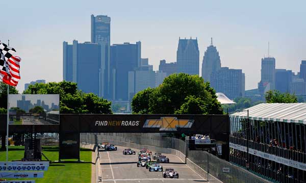 Cars racing on Belle Isle with the Detroit skyline in the background