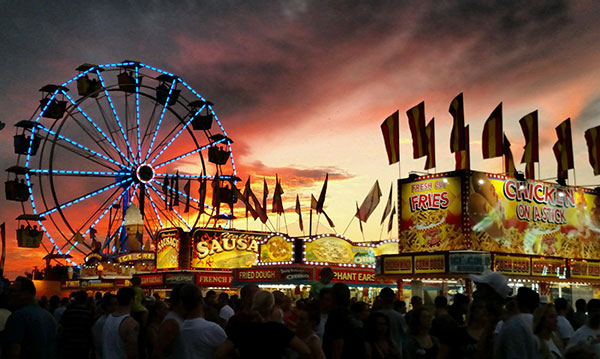 Silhouettes of a carnival on a pink and grey sky