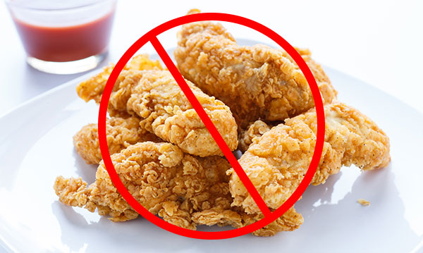 Chicken strips on a white plate with a big red no sign through it