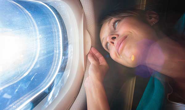 Woman looking out airplane window