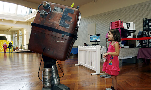 Child looks at an invention from Maker Faire Detroit