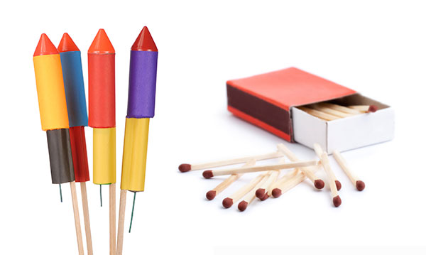 Four Roman candles and a box of matches on a white background