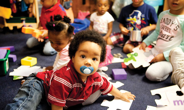 Boy with pacifier in his mouth looking at camera